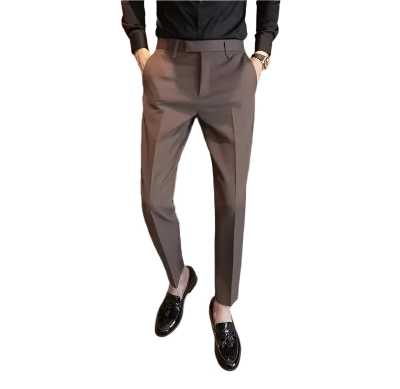 Person wearing brown dress pants and black shoes in a minimal indoor setting
