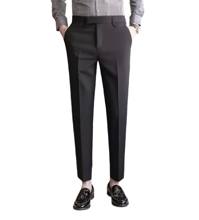 Dark gray dress pants worn by a person on a white background