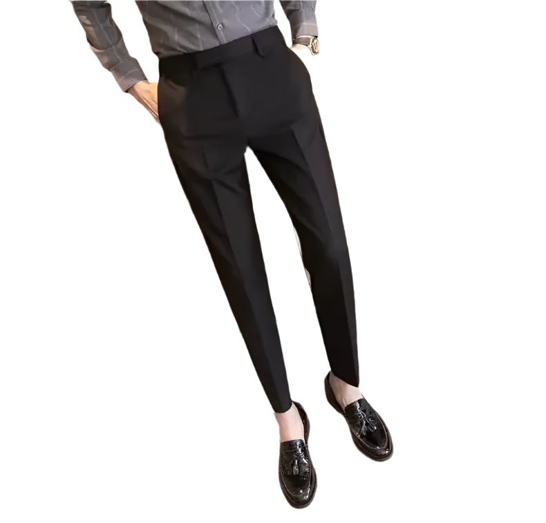 Person wearing black pants and black shoes in a minimal indoor setting