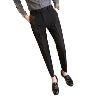 Person wearing black pants and black shoes in a minimal indoor setting